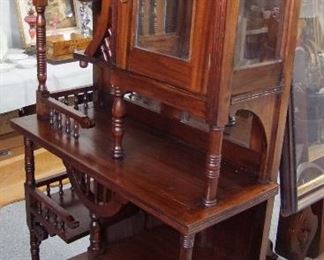 Lot 32A   C/1880 Mahogany Eastlake Display Vitrine.  Beveled glass mirrors in back & enclosure, Some Carving with spindle decorations.   36"w. X 15"d. X 72"h. Condition: Refinished, display door slightly warped.   Est. $300 - 500