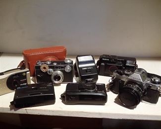 Assortment of cameras including a Canon AE1 and attachments, a Vivitar, Olympus, Keystone, etc.
