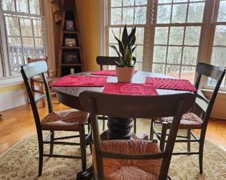 Antique (talking hiding money in the hollow turned pedestal old) ball and claw foot kitchen table. 4 like new rush bottom chairs. Canoe display shelf in corner.