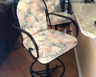 Two wrought iron swivel bar chairs