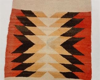  NAVAJO HAND MADE WOOL MAT. 17.5" X 21". ACTUAL COLORS ARE SALMON IN THE CENTER AND SLIGHTLY MAUVE ON THE EDGES. STAIN AND FOREIGN MATERIAL IN THE CENTER.
