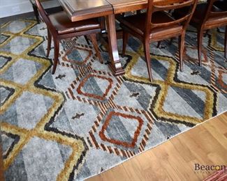 Multi-colored red rug. Measures approx. 13'5” x 12'