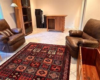 Tribal Area Rug, Large Faux Leather Recliner Chairs, Wood Bar Cabinet, Vintage Glass Front Cabinet, Land Furniture Chest, and Audio Speaker Equipment