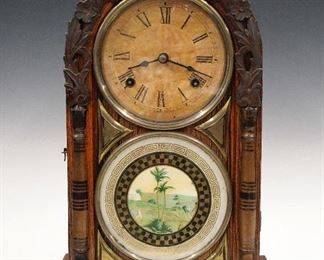 A 19th century round top shelf clock.  8-day time and strike movement with a papered metal dial and Roman numerals.  Grain painted case with arched top over a single door with clear dial glass and reverse painted lower with Brass bezels and applied decoration, on a simple squared base.  Old finish with minor damage, replaced paper on dial, running when cataloged.  17 1/4" high.  ESTIMATE $100-150