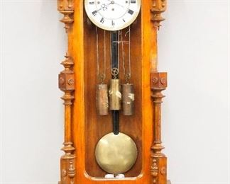 A late 19th century Vienna Regulator wall clock.  8-day weight driven time and strike movement with quarter hour Grand Sonnerie strike, two part porcelain dial with Roman numerals and brass bezel.  Walnut case with an arched crown over a single long door with arched  glass and turned pilasters and shaped bracket drop.  Older refinishing with some wear,  lacks crest and several finials, not running when cataloged.  38 1/2" high.  ESTIMATE $100-200
