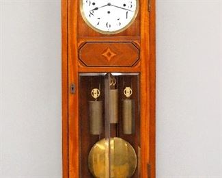 A late 19th century Vienna Regulator wall clock.  8-day weight driven time and strike movement with quarter hour Grand Sonnerie strike, two part porcelain dial with Roman numerals and brass bezel.  Mahogany case with inlaid detail features a single long door with circular dial glass and beveled lowers, above a shaped bracket drop.  Older refinishing with some wear, dial damage, not running when cataloged.  35" high.  ESTIMATE $100-200
