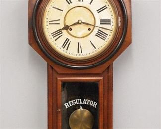 A late 19th century Ansonia "Regulator A" model schoolhouse clock.  8-day time and strike movement with two part papered metal dial and Roman numerals.  Mahogany long drop case with octagon top and lower stenciled door.  Paper label 50%.  Original finish with Ebonized detail, some wear, dial discoloration, running when cataloged.  32" high.  ESTIMATE $100-200
