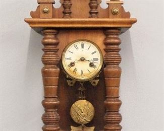 A 20th century Junghans wall clock.  8-day time and strike movement with papered metal dial, Roman numerals and embossed pendulum.  Mixed wood case with Walnut finish, shaped crest arched door with turned pilasters and shaped drop.  Minor wear, dial discoloration, running when cataloged.  29 1/2" high.  ESTIMATE $100-150
