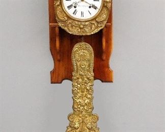 A late 19th century French Morbier clock movement with a custom made wall bracket.  8-day weight driven time and strike movement with convex porcelain dial, Roman numerals and fancy embossed Brass bezel and pendulum.  Some damage to Brass, dial imperfections, replaced weights, not running when cataloged.  62" high plus weight drop.  ESTIMATE $200-300

