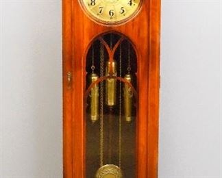 A 1930's vintage German hall clock by Kienzle.  8-day weight driven time and strike movement with quarter hour Westminster chimes, a Brass dial with Arabic numerals, matching Brass weights and pendulum.  Walnut case with peaked top over a long door with circular dial glass and fretwork on a paneled base with molded feet.  Older finish with minor wear, running when cataloged.  77" high.  ESTIMATE $400-600
