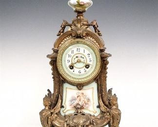 A turn of the century H & H Louis XV style mantel clock.  8-day time and strike movement with painted porcelain dial.  Spelter case with painted porcelain finial insert and lower panel.  Some finish wear, replaced wooden base panel, running when cataloged.  15 1/2" high.  ESTIMATE $200-300
