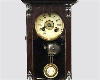 A turn of the century miniature German wall clock.  30-hr spring driven time and alarm movement with a 3 3/4" flat painted metal dial, Roman numerals and R/A pendulum.  Mahogany case with pediment top and single door over a shaped drop.  Old finish with Ebonized detail, slight wear, restored crest, running momentarily when cataloged.  19 3/4" high.  ESTIMATE $400-600
