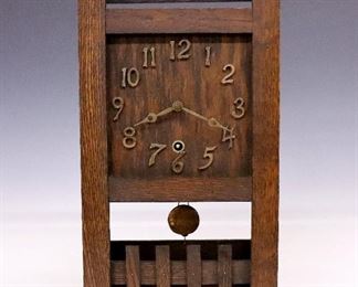 A turn of the century American Arts and Crafts shelf clock.  8-day time only movement with a wooden dial and applied Arabic numerals.  Oak case with slatted sides on a stretcher base with lattice detail.  Refinished with minor wear, dents on pendulum, running when cataloged.  17" high.  ESTIMATE $400-600
