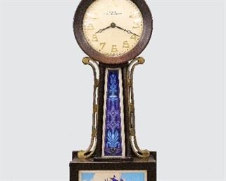 An early 20th century New Haven "Willis" miniature Banjo clock.  12-day jeweled time only movement with a Silvered dial and Arabic numerals.  Mahogany case with Brass Eagle finial, original reverse painted throat flanked by shaped Brass side arms and lower glass depicting a Naval scene.  Paper label 80% intact.  Original dark finish with minor wear, running when cataloged.  17 1/2" high.  ESTIMATE $400-600
