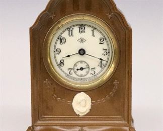 An early 20th century miniature Waterbury desk clock in a Benedict Bronze case.  30-hr time only movement with a porcelain dial, Arabic numerals and subsidiary seconds.  Chippendale style Bronze case with painted medallion.  Minor wear, running when cataloged.  4 3/4" high.  ESTIMATE $50-75
