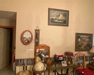 marble accent table, globe on stand, metal and glass side table, misc mirror, artwork, decorative clock and an ornate chair that looks like a big top circus 