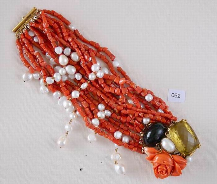 Iradj Moini Spectacular multi-strand bracelet measures 7 7/8” in length. Large rose carved coral, 18 strands red coral pieces, white fresh water pearls, oval cabochon black onyx/glass, citrine, oval fresh water pearl.
