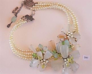 Caroline 15” necklace has a 2” jump ring extension. Four strands of light green fresh water pearls have a large 3 part center grouping of mixed rose quartz-colored stones and faceted peridot pear shaped stones. Groups have fresh water pearl cluster centers.