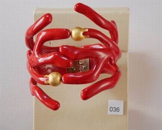 Gold tone and molded red plastic to imitate red coral, hinged bangle bracelet. One piece on either side has a gold tone, cap with overall tiny beading. 