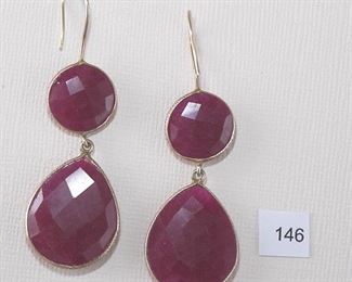 Pierced ear wire. Gold tone. Mark illegible. 2 1/2” in length. One round faceted, front and back, reddish purple stone, probably genuine and dyed, but undetermined and one larger pear shaped drop, both bezel set.