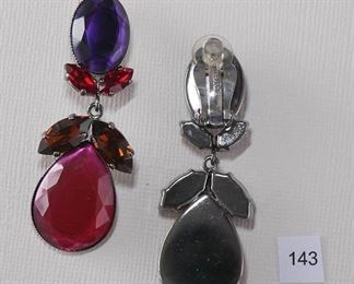 P. Ferrands Clip back Silver Tone. Approximately 2 1/4” in length and 7/8” in width. Top stone cut in half is an oval faceted dark purple bezel set. Below are two red faceted marquise shaped stones. The drop is two brown faceted marquise shaped stones and a large stone cut in half, pear shaped bright pink. All stones closed back.
