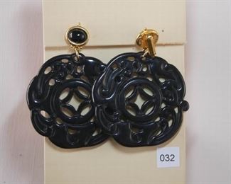 Kenneth Lane. Measures approximately 2 3/4” in length. Black molded plastic cut out disc measures approximately 2 1/8” in diameter. At the top is an oval cabochon plastic set horizontally in a bezel.