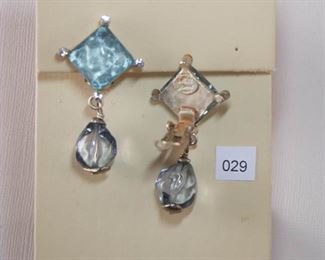 Cecile Jeanne Paris. 2 1/8” in length. Square top is set with light blue, transparent textured stone measuring approximately 16mm with a foil back clear faceted stone in each corner. The drop is a light blue transparent drop form fully drilled.