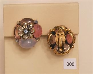 Iradj Moini. Clip back earrings measure approximately 1 1/4” in diameter. Each earring has a flower stay center with one faceted light blue stone surrounded by 7 faceted pear shape transparent stones, green quartz. Around the flower center are 3 oval cabochon stones in 3 shades of pink/rose. Set between the cabochons are 2 faceted light blue and light green stones.