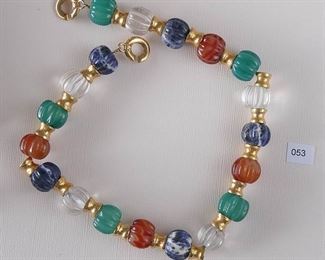 Francesca Romana. Necklace measures approximately 17 1/4” in length. There are 19 rounded ribbed stones: sodalite, clear quartz, green onyx, carnelian etc, each measures approximately 16mm in diameter and are separated by a gold tone “hourglass “ rondel. The necklace matches the earrings # 014 and # 015.