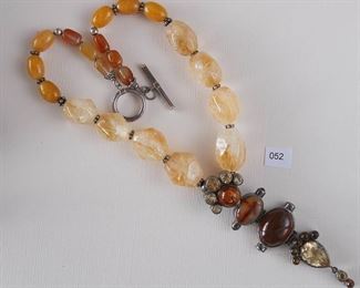 Starborn. Stamped 925 Sterling. The single strand necklace measures approximately 17 1/2” in length. Multiple stones and shapes uncle: citrine, carnelian, amber, and quartz. From the beads at the center is a 4” silver drop with bezel set multiple stones, the necklace has a silver toggle clasp.