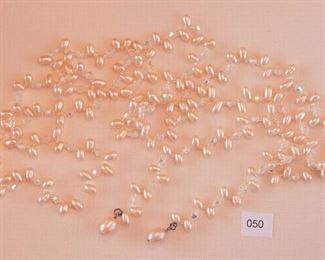 Silver Tone end pieces. The single strand necklace measures approximately 41 3/4” in length. The strand has multiple light pink fresh water pearls separated by clear faceted crystals. No clasp.