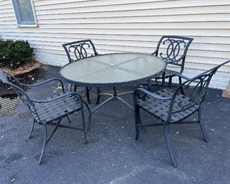 Outdoor wrought iron glass-top table with wrought iron chairs