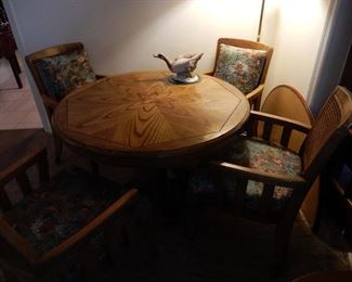 Oak round game table with four arm chairs on rollers