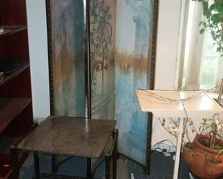 Folding screen, utility tables, plants and bookcases.