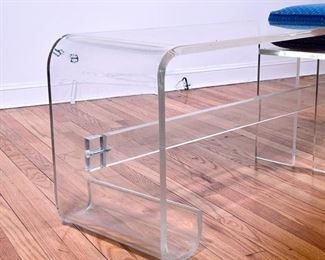 KAGAN STYLE LUCITE BENCH  |  Having a single seat with an upholstered cushion next to an extended low form table, in the manner of Vladimir Kagan - l. 58 x w. 15 x h. 20 in. (over cushion)
