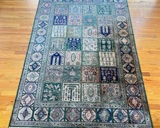 GEOMETRIC FLORAL RUG  |  Green rug with fringe, having a geometric outer border surrounding a field of square floral patterns - approx. l. 87 x w. 58 in.