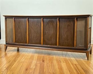 MAGNAVOX STEREO CONSOLE  |  Long mid century modern stereo console with built in record player by Magnavox; walnut panels, sliding door top; c.1960s - l. 59 x w. 18 x h. 26 in.