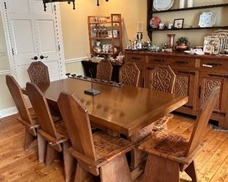 This dining set was purchased in the early 1950s by our homeowner's in-laws. It was hand carved in Brittany, France by master carpenters.  Truly unique and a show-stopper!  The seats are woven in leather! 