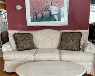 Ivory camel back sofa with rolled arms,&nbsp;and oval marble top coffee table