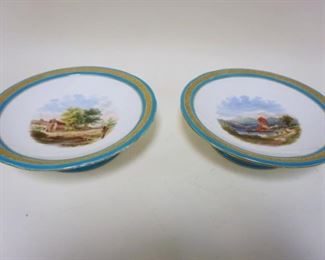 1061	HAND PAINTED COMPOTES W/BLUE & GILT DECORATED BORDER, SCENES OF LANDSCAPES W/STRUCTURES AT WATERS EDGE, APPROXIMATELY 9 1/4 IN X 2 1/4 IN HIGH
