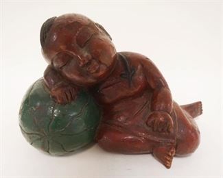 1202	ASIAN WOOD CARVING OF A YOUNG BOY SLEEPING ON A MELON, APPROXIMATELY 14 IN X 10 IN HIGH
