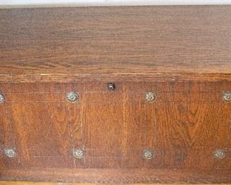 antique cedar chest with oak veneer on outside.