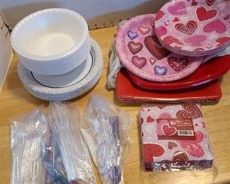 Paper and plastic plates, styrofoam bowls, napkins, plastic cutlery in large basket