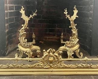 Turn of the century gilt bronze “Chenet” fireplace set, pair of sculptured andirons and matching low fender.