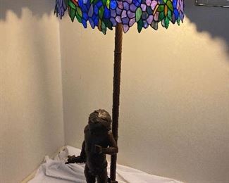 Bronze statue based floor lamp with Tiffany style shade. Holds 3 bulbs.