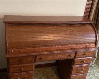Roll Top Desk
Wooden roll top desk with five drawers and upper shelf with dividers.&nbsp;
