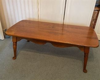 Solid wood coffee table, medium wood tone coloring with some wear on finish.