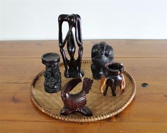 Group of African Wood Carvings on woven tray. Height of tallest 12”, Diameter of tray 18”.
