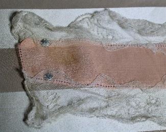 Detail on antique boudoir cap, two crochet lace sachets, and lace and silk belt with ribbon roses