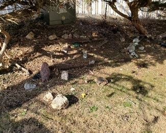 There are rocks and small animal figures in the back yard